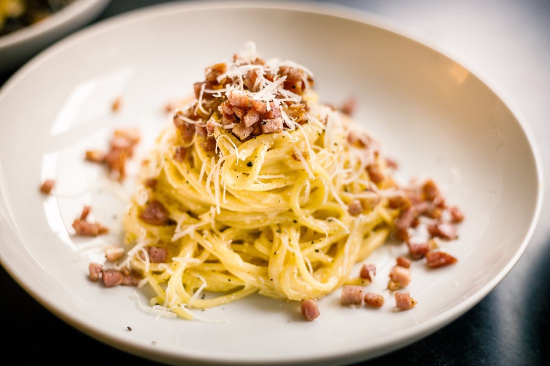 Spaghetti alla carbonara serviti su un piatto bianco