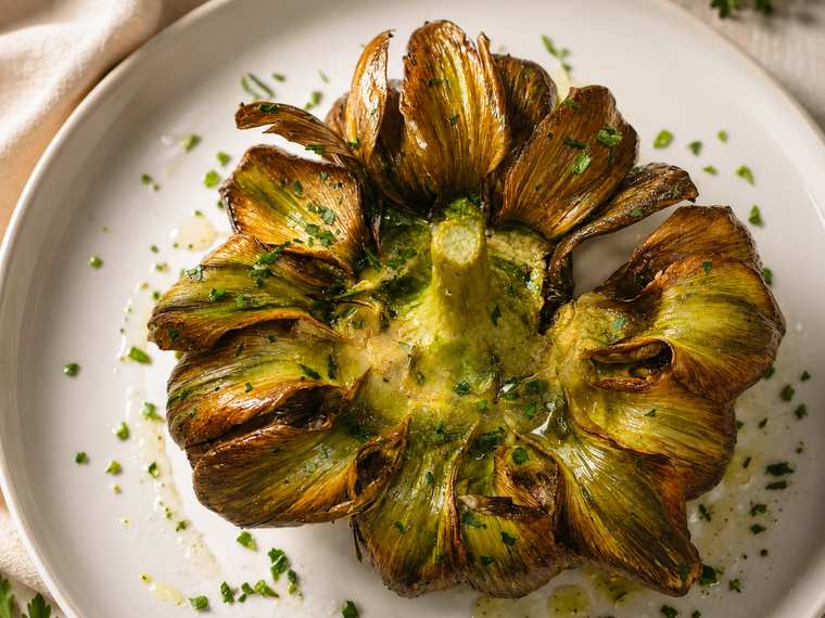 Carciofo aperto a fiore, dorato e croccante, con prezzemolo