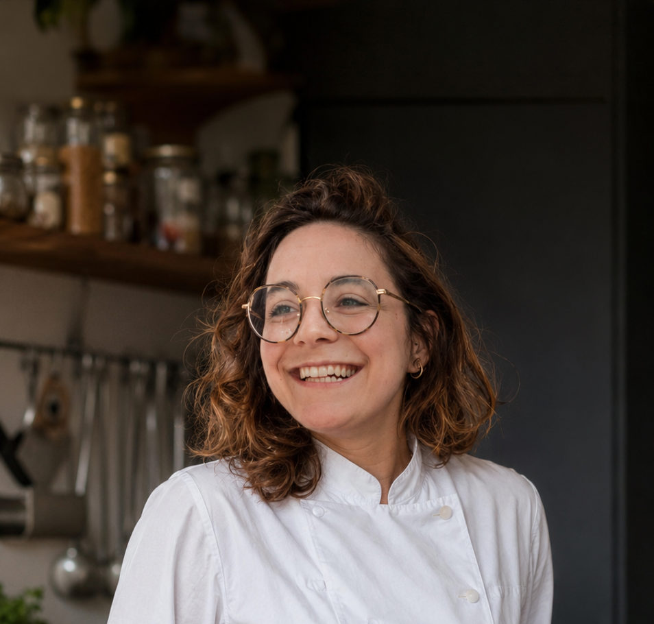 Carola Castiglione sorride nella sua cucina, in giacca bianca da chef