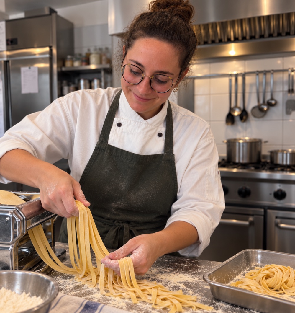 Carola stende a mano le tagliatelle fresche con la sfogliatrice, in cucina