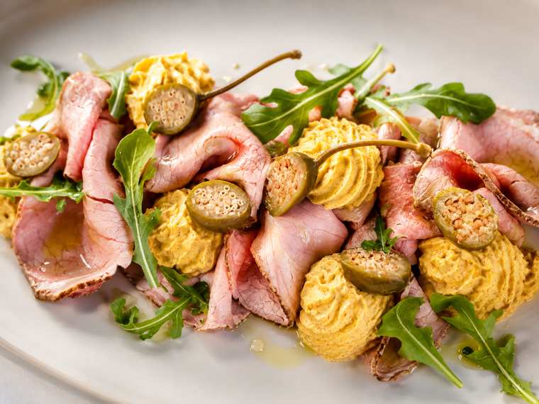 Fette di roast beef rosato con ciuffi di salsa tonnata e capperi